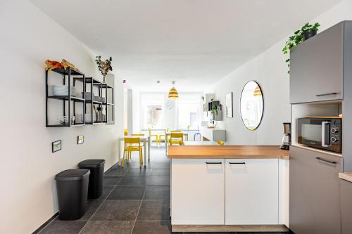 a kitchen with white cabinets and a table with chairs at Le Gîtel in Spa