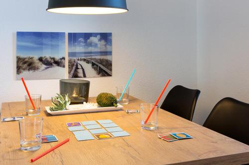 - une table en bois avec des verres à boire et des baguettes dans l'établissement Woge2 Appartement 9, à Borkum