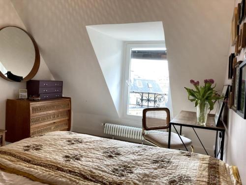 une chambre avec un lit, un miroir et une chaise dans l'établissement Appartement cosy dans le 9e, à Paris