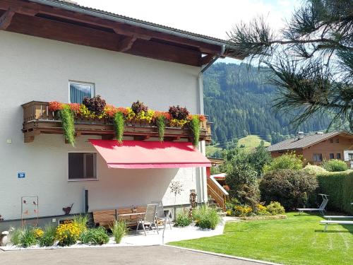 ein Haus mit einem Balkon mit Blumen darauf in der Unterkunft Apartment Rupertus-3 by Interhome in Maishofen