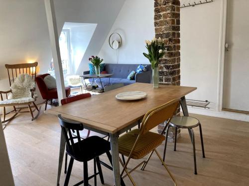 un salon avec une table et des chaises en bois dans l'établissement Appartement cosy dans le 9e, à Paris