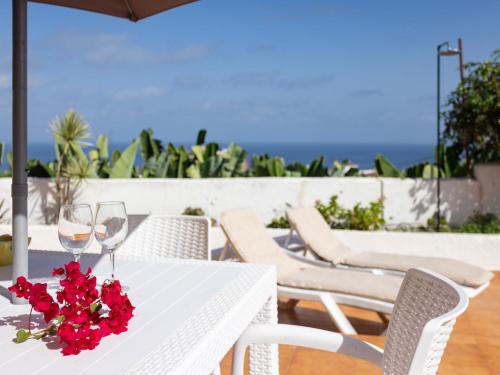 una mesa blanca con copas de vino y flores. en Holiday Home Barreto by Interhome, en Puerto de la Cruz