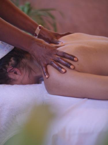 a woman getting a massage on her back in a bed at Tulia House Backpackers in Mombasa
