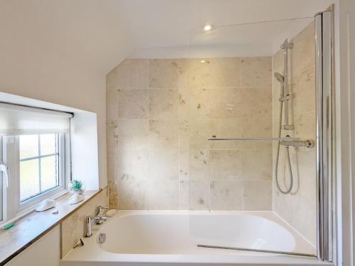 a bathroom with a large tub and a shower at Spence Cottage, Birdham in Birdham