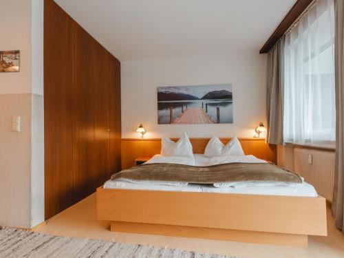 ein Schlafzimmer mit einem großen Bett und einem großen Fenster in der Unterkunft Apartment Sepp by Interhome in Bad Hofgastein