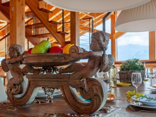 a wooden table with a bowl of fruit on it at Chalet Chalet Aquarius by Interhome in Nendaz