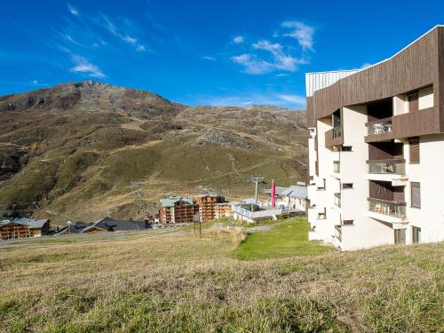 un bâtiment sur une colline avec une montagne en arrière-plan dans l'établissement Apartment Origanes 225 by Interhome, aux Menuires