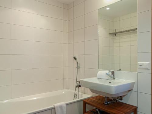 a white bathroom with a sink and a bath tub at Chalet Chalet Aquarius by Interhome in Nendaz