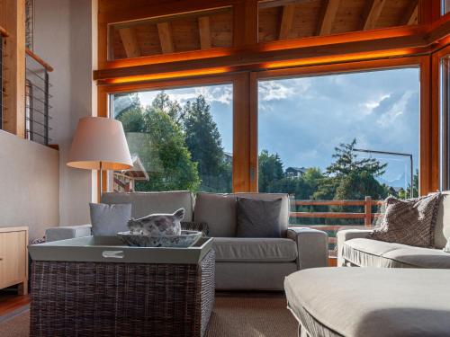 a living room with a couch and a large window at Chalet Chalet Aquarius by Interhome in Nendaz