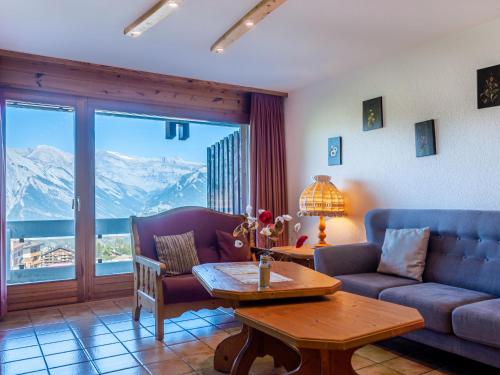 a living room with a couch and a table at Apartment Hauts De Nendaz B OP by Interhome in Nendaz