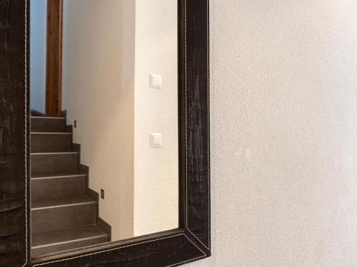 a mirror on a wall next to a staircase at Chalet Chalet Aquarius by Interhome in Nendaz