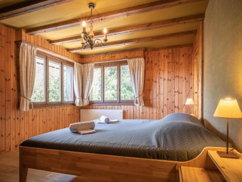 オヴロナにあるApartment Le Mélèze by Interhomeのベッドルーム1室(木製の壁と窓のあるベッド1台付)
