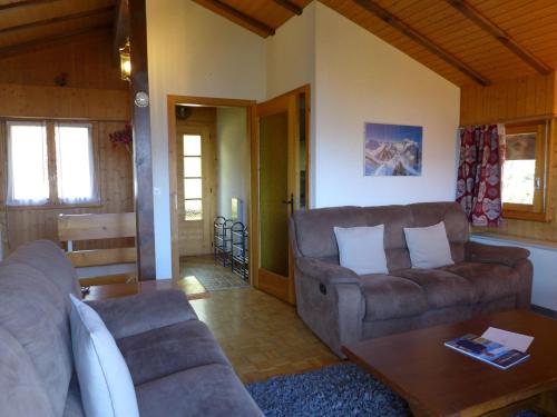 Sala de estar con 2 sofás y mesa en Chalet Moulinettes N- 8 by Interhome, en Bluche