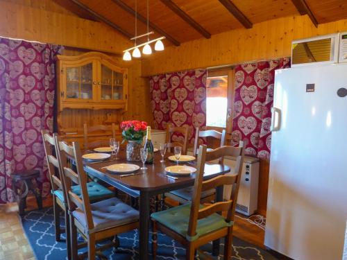 a dining room with a table and a refrigerator at Chalet Moulinettes N- 8 by Interhome in Bluche