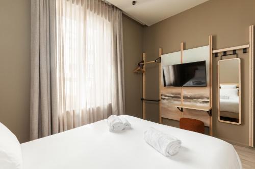 een hotelkamer met 2 bedden en een televisie bij Gogaille - Gambetta - accès autonome in Limoges