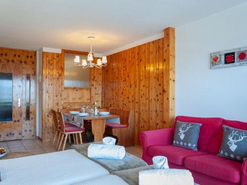 ein Wohnzimmer mit einem roten Sofa und einem Tisch in der Unterkunft Apartment Christiania 2 L1 by Interhome in Nendaz