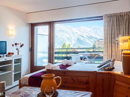 a bedroom with a large window with a view of the mountains at Apartment Christiania 2 O1 by Interhome in Nendaz