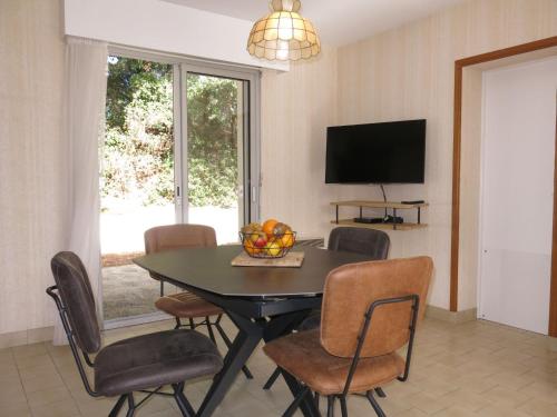 une salle à manger avec une table, des chaises et une télévision dans l'établissement Holiday Home Les Algues by Interhome, à La Tranche-sur-Mer