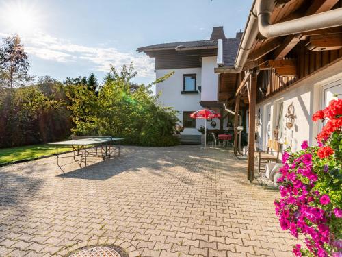 a patio with a table and flowers next to a building at Apartment Alpenrose Apartment 2 by Interhome in Sankt Urban