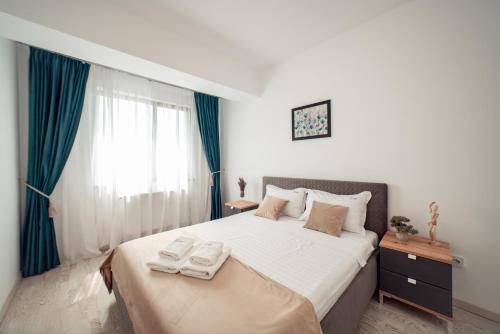 a bedroom with a bed with two towels on it at COZY APARTHOTEL - Ultracentral Luxury Apartments Iasi in Iaşi