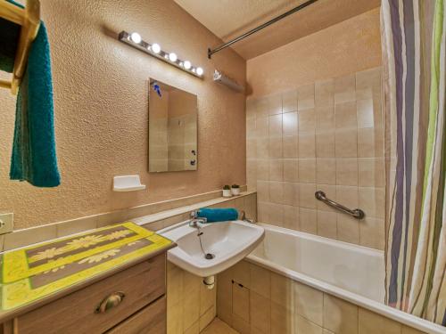 a bathroom with a sink and a bath tub at Apartment Vostok Zodiaque-61 by Interhome in Le Corbier