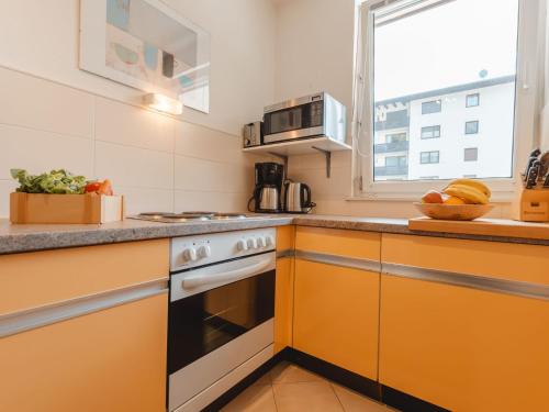 kuchnia z pomarańczowymi szafkami i kuchenką w obiekcie Apartment Martini by Interhome w mieście Bad Gastein