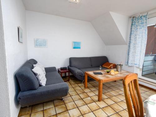 een woonkamer met een bank en een tafel bij Apartment Muschelweg-1 by Interhome in Norddeich