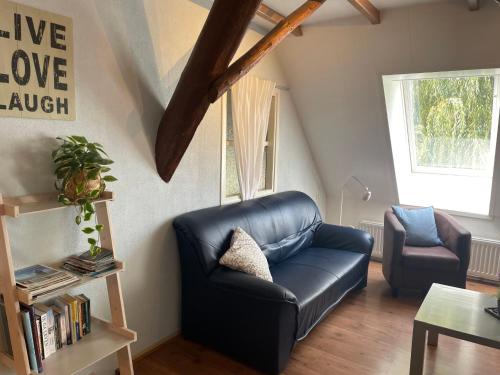 a living room with a leather couch and a chair at Holiday Home De Dars by Interhome in Stolpen
