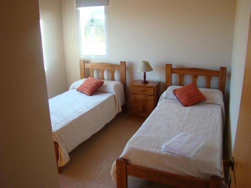 - une chambre avec 2 lits et une fenêtre dans l'établissement Cabañas De Los Tios, à Sierra de la Ventana