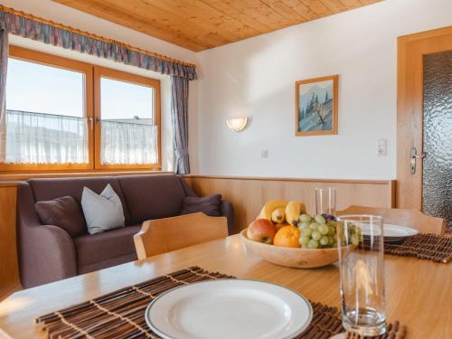 een woonkamer met een tafel met een fruitschaal bij Apartment Voithofer-1 by Interhome in Königsleiten