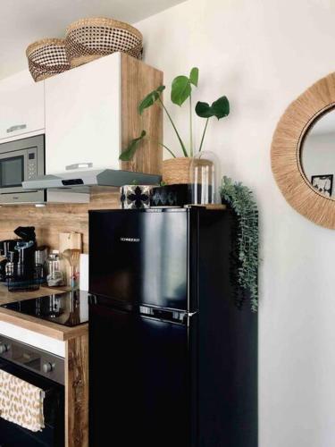 - une cuisine avec un réfrigérateur noir dans la chambre dans l'établissement STUDIO COSY PROCHE DISNEY, à Chalifert