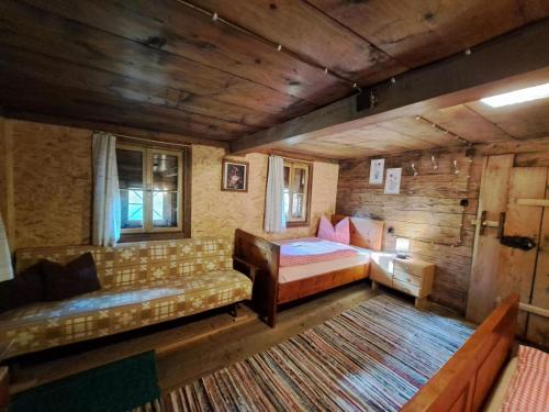 a bedroom with a bed and a couch in a cabin at Chalet Lippnerhütte by Interhome in Tux