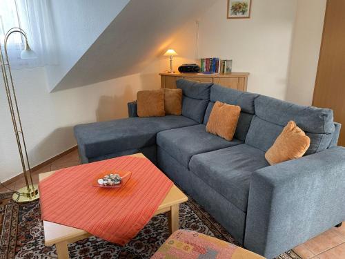 Una sala de estar con un sofá azul y una mesa. en Apartment Lemke by Interhome, en Prerow