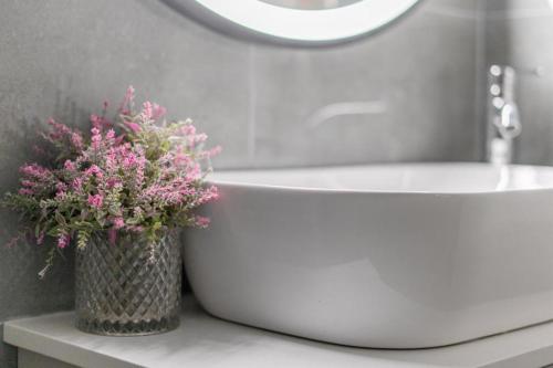 a bathroom with a white tub and a vase of flowers at Stavri De'Lux Apartment in Larnaka
