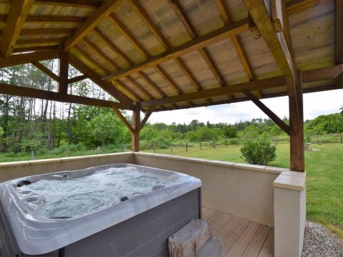 a hot tub on a deck with a wooden roof at Holiday Home Au Cayroux - BSB302 by Interhome in Blanquefort-sur-Briolance