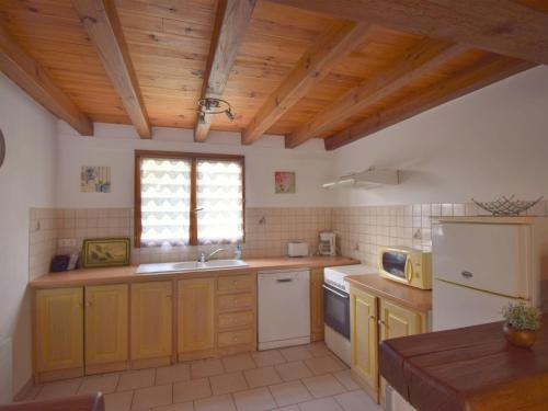 a kitchen with wooden ceilings and a white refrigerator at Holiday Home Au Cayroux by Interhome in Blanquefort-sur-Briolance