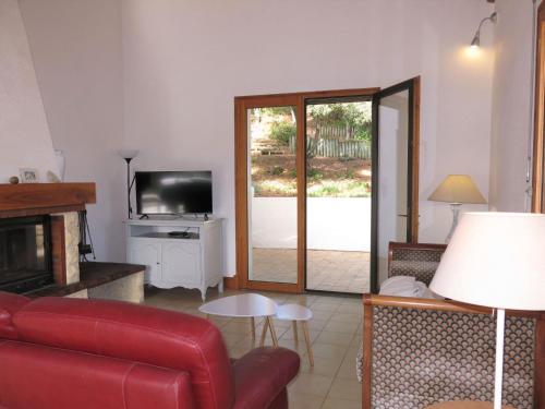 un salon avec un canapé rouge et une télévision dans l'établissement Holiday Home Les Bars by Interhome, à La Tranche-sur-Mer