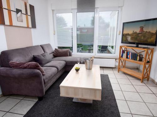 a living room with a couch and a coffee table at Holiday Home Seefalke by Interhome in Norddeich