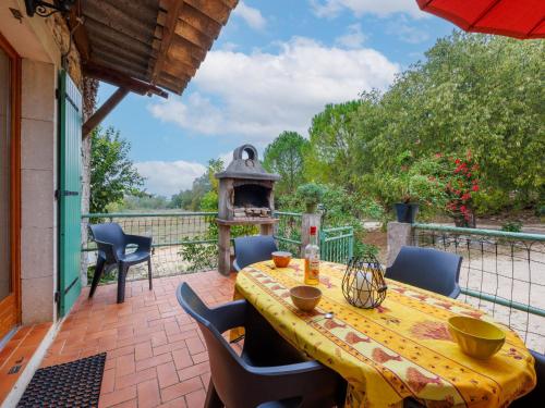 einen Tisch und Stühle auf einer Terrasse mit einem Pizzaofen in der Unterkunft Holiday Home Lozard by Interhome in Barjac
