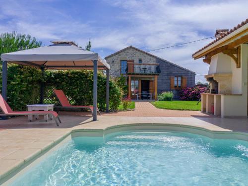 een zwembad met een parasol en een huis bij Holiday Home Madaillan - PRY300 by Interhome in Madaillan