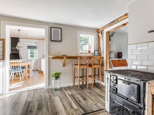 a kitchen with a stove and a dining room at Holiday Home Aspenäs by Interhome in Falköping