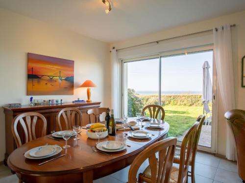 ein Esszimmer mit einem Tisch und einem großen Fenster in der Unterkunft Holiday Home Mer d'Iroise 1 - LCQ104 by Interhome in Le Conquet