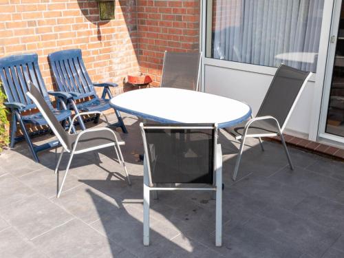 een tafel en stoelen op een patio bij Holiday Home Storchennest by Interhome in Norddeich