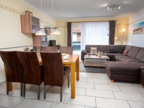 een woonkamer met een tafel en een bank bij Holiday Home Storchennest by Interhome in Norddeich