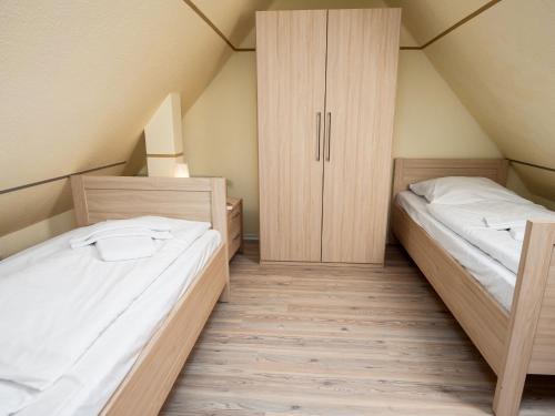 a room with two beds and a closet at Holiday Home Storchennest by Interhome in Norddeich