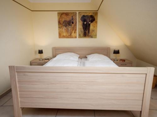 a bed in a bedroom with two night stands and two lamps at Holiday Home Storchennest by Interhome in Norddeich