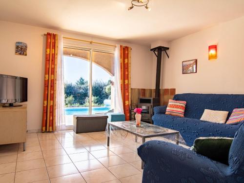 ein Wohnzimmer mit einem blauen Sofa und einem Tisch in der Unterkunft Holiday Home Mistral - REG110 by Interhome in Régusse