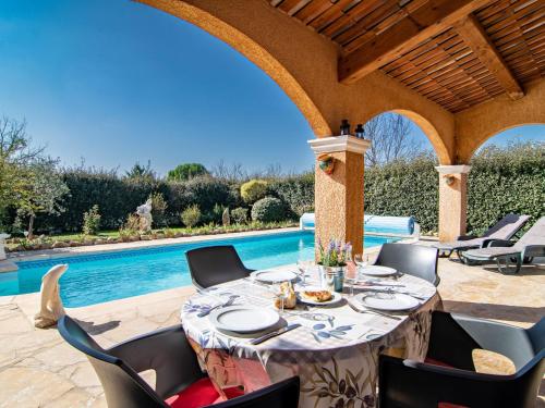 - une table à manger sous une pergola à côté de la piscine dans l'établissement Holiday Home Mistral by Interhome, à Régusse