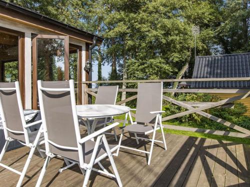 un patio con mesa y sillas en una terraza en Holiday Home Kjuge Gula Huset - SKO039, en Fjälkinge
