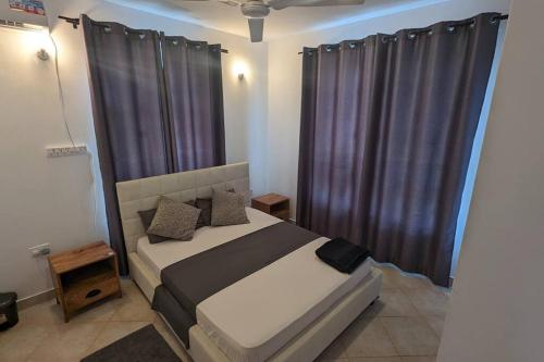 a bedroom with a bed with black curtains at Mawingu Loft in Malindi